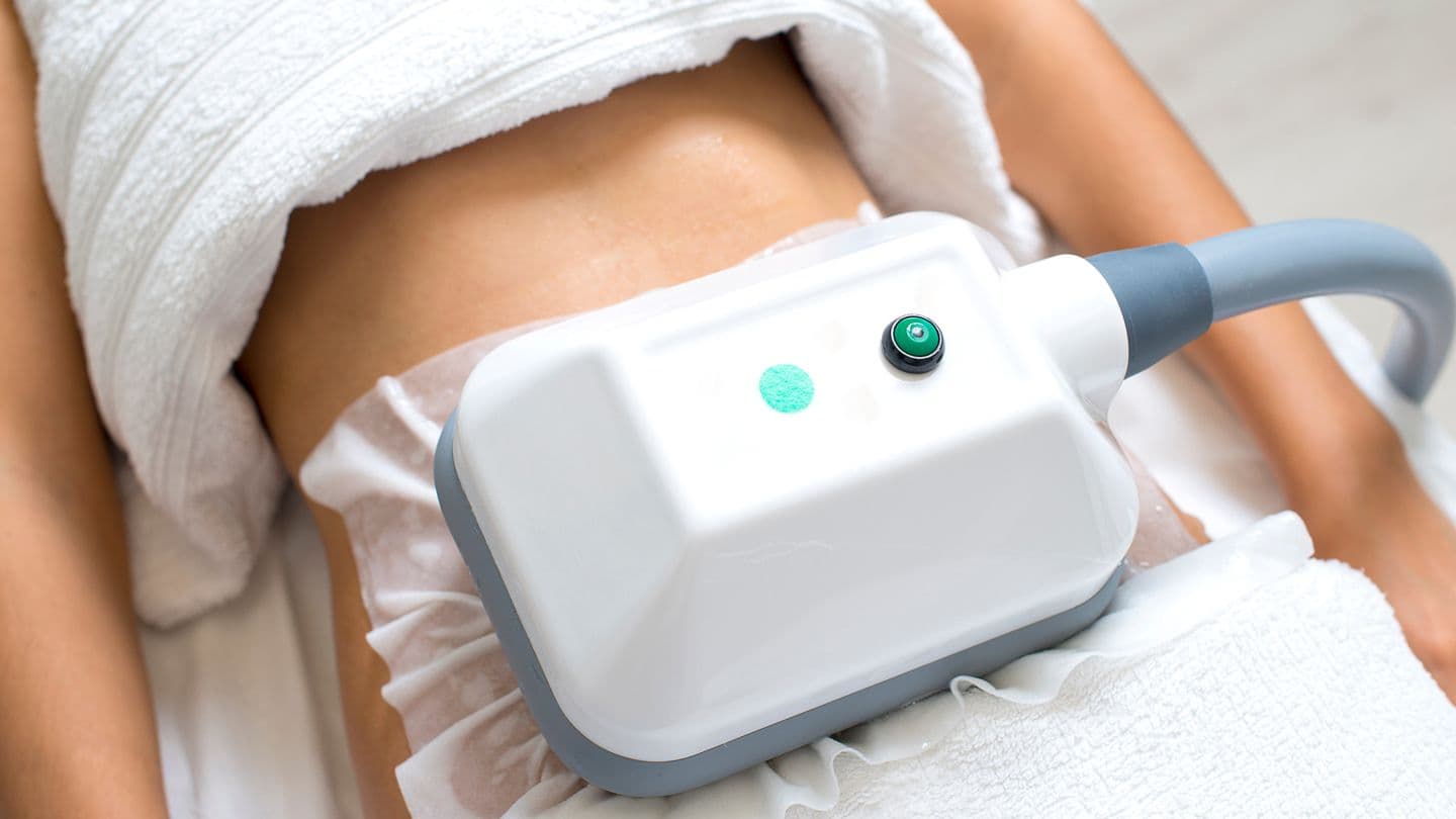 Cool sculpting applicator positioned on a patient's abdomen at The Aesthetic Edge