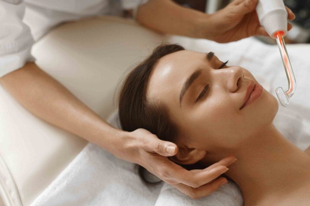 High-frequency glass electrode being applied to a patient's scalp at The Aesthetic Edge